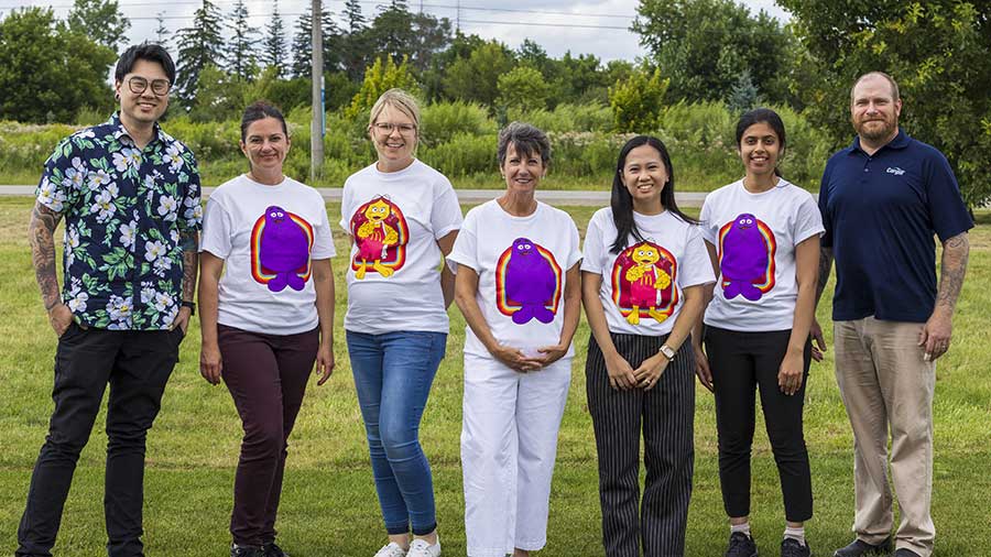 Several Cargill and McDonald’s employees stand in a field of grass and smile.